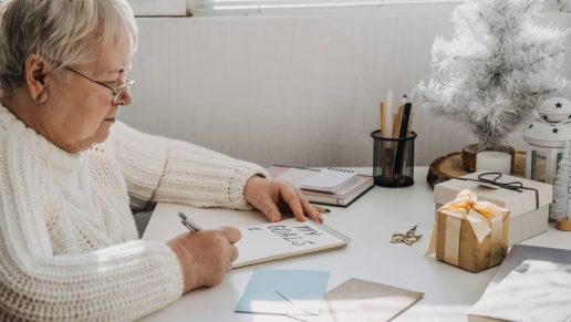 An senior woman writing Goals on a paper.